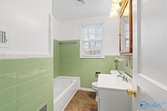 full bathroom featuring tile walls, visible vents, toilet, a sink, and a tub