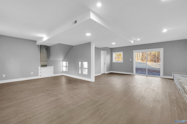 unfurnished living room with vaulted ceiling and hardwood / wood-style floors