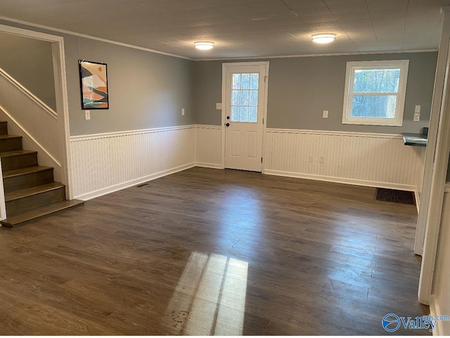 foyer with dark wood-type flooring, plenty of natural light, and ornamental molding