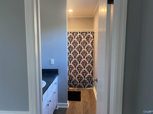 bathroom with vanity, wood-type flooring, and ornamental molding