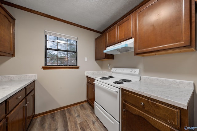 kitchen featuring light countertops, dark wood finished floors, under cabinet range hood, electric stove, and ornamental molding