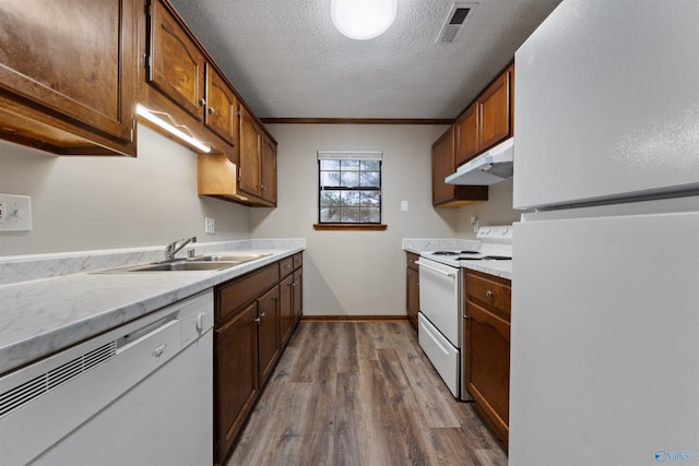 kitchen with white appliances, visible vents, light countertops, and under cabinet range hood