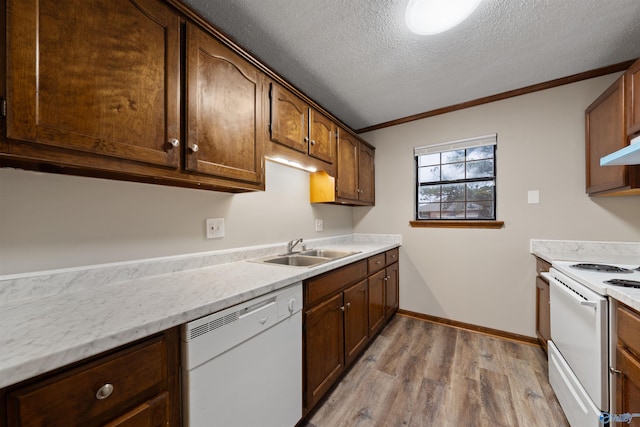 kitchen featuring a textured ceiling, light countertops, white appliances, a sink, and light wood-style floors