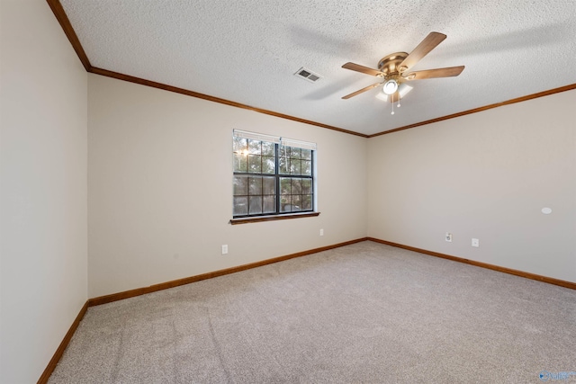 unfurnished room featuring crown molding, carpet floors, a ceiling fan, baseboards, and visible vents