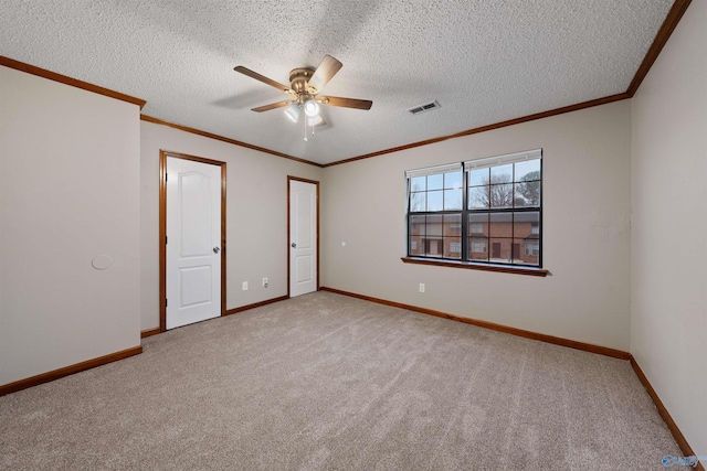 spare room featuring a ceiling fan, light carpet, baseboards, visible vents, and ornamental molding
