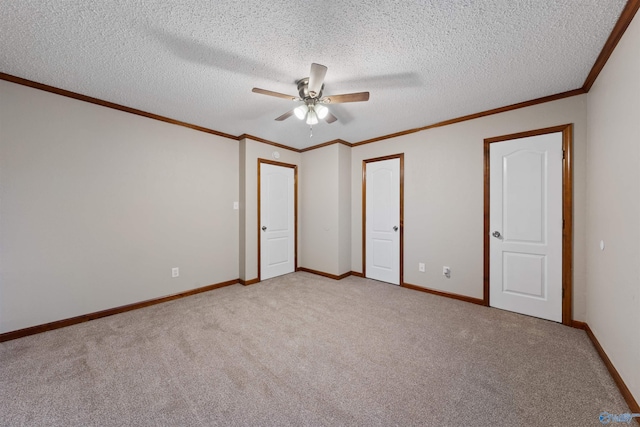 unfurnished bedroom with light colored carpet, ornamental molding, baseboards, a textured ceiling, and ceiling fan