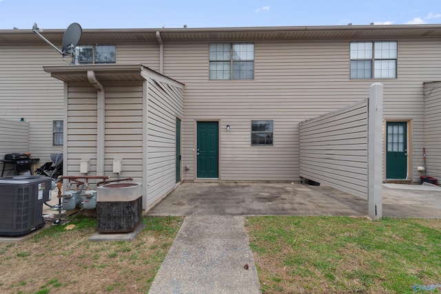 rear view of property featuring cooling unit and a patio area