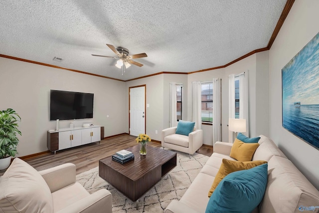 living room with a textured ceiling, visible vents, ceiling fan, wood finished floors, and ornamental molding
