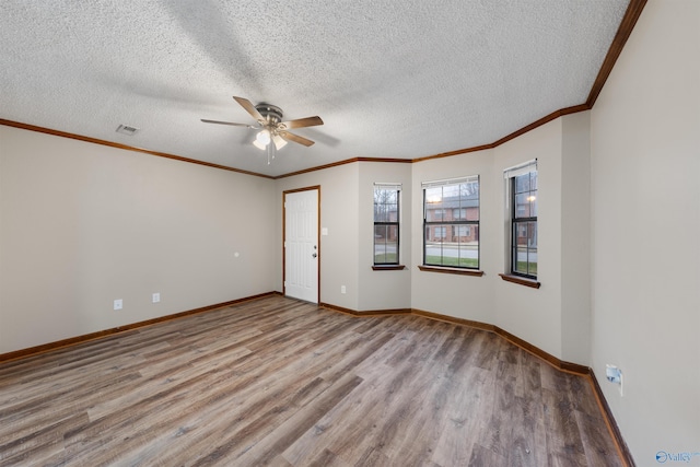 spare room featuring baseboards, ceiling fan, wood finished floors, and ornamental molding