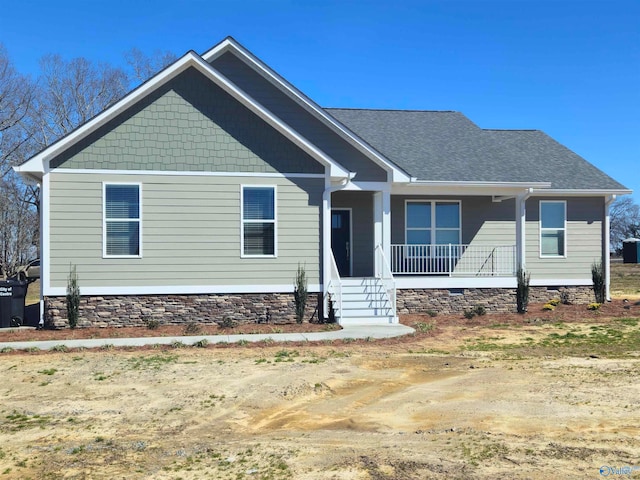 craftsman-style home featuring covered porch, a shingled roof, and crawl space