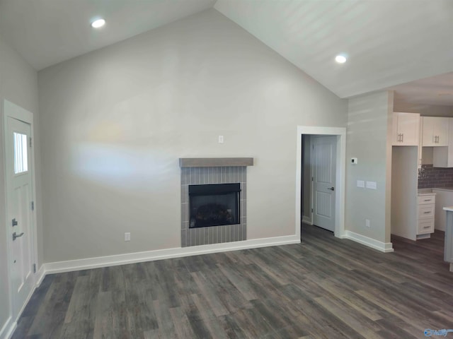 unfurnished living room with lofted ceiling, dark wood-style floors, a fireplace, and baseboards