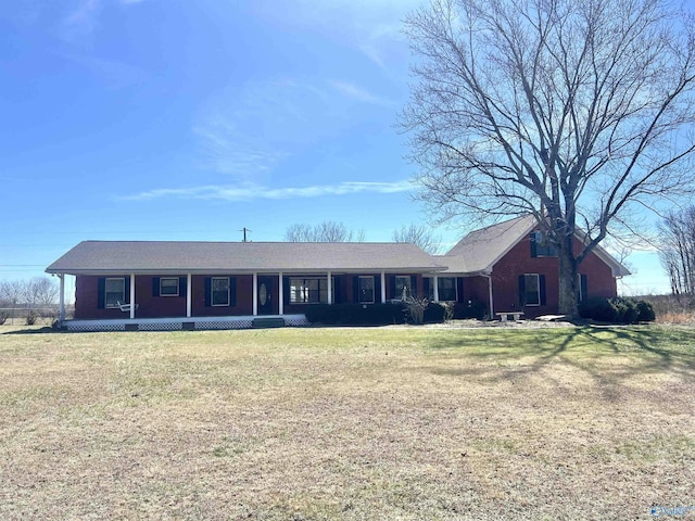 single story home featuring covered porch and a front yard