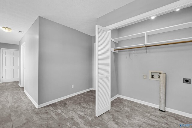 interior space featuring electric dryer hookup, hookup for a washing machine, and light tile patterned floors