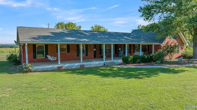 ranch-style house featuring a porch, a front yard, brick siding, and a shingled roof