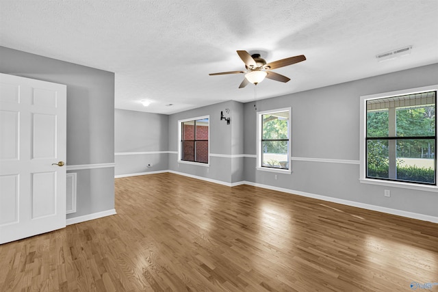 unfurnished room featuring ceiling fan, wood-type flooring, and a textured ceiling