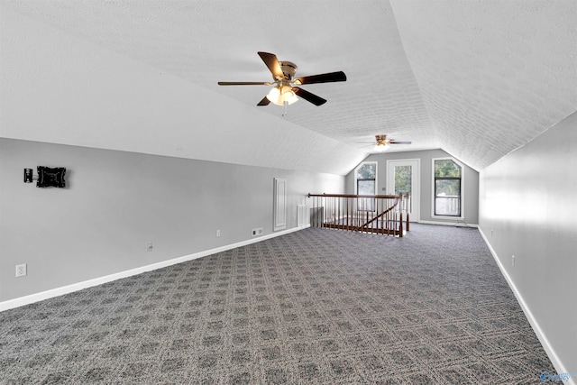 bonus room featuring ceiling fan, carpet, a textured ceiling, and lofted ceiling