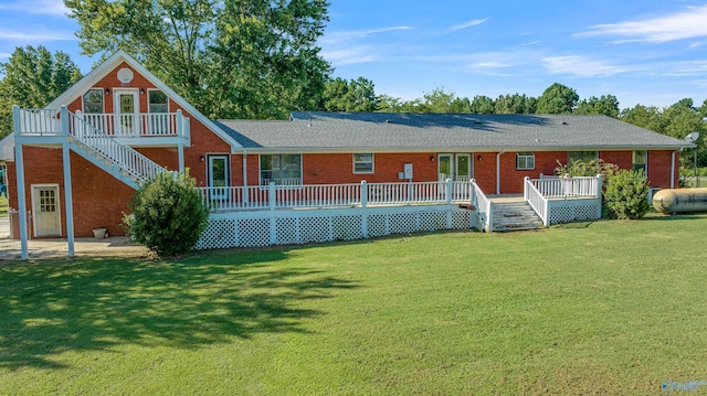 rear view of house with a yard and a wooden deck