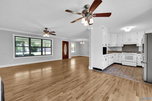 interior space featuring ceiling fan with notable chandelier, a wealth of natural light, and hardwood / wood-style flooring