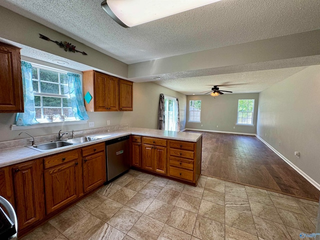 kitchen with dishwasher, kitchen peninsula, sink, ceiling fan, and light wood-type flooring