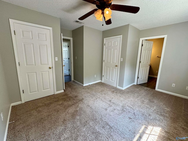 unfurnished bedroom with a textured ceiling, carpet, and ceiling fan