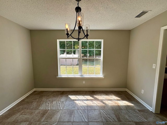 unfurnished room with an inviting chandelier and a textured ceiling