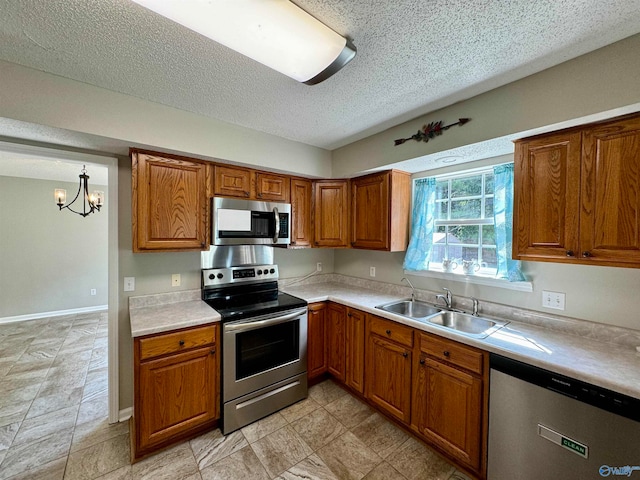 kitchen with stainless steel appliances, a chandelier, a textured ceiling, and sink