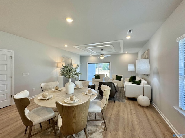 dining space with visible vents, baseboards, light wood-style floors, and attic access