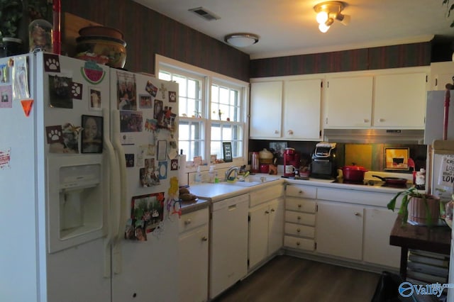 kitchen featuring wooden walls, sink, white cabinetry, white appliances, and dark hardwood / wood-style flooring