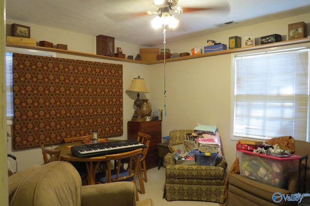 living area featuring carpet flooring and ceiling fan