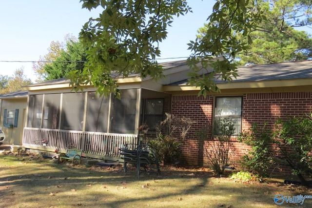 view of property exterior featuring a lawn and a sunroom