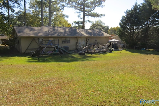 rear view of house with a yard and a deck