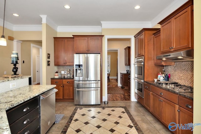 kitchen with decorative light fixtures, ornamental molding, appliances with stainless steel finishes, light stone countertops, and backsplash