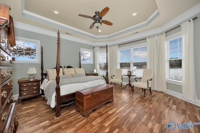 bedroom with hardwood / wood-style flooring, ceiling fan, a tray ceiling, and crown molding