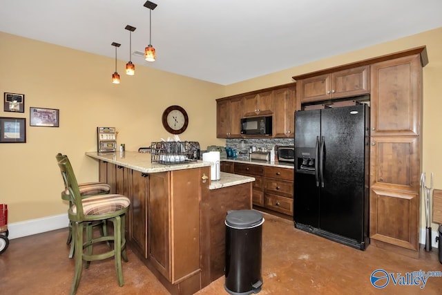 kitchen featuring pendant lighting, a breakfast bar, light stone countertops, black appliances, and kitchen peninsula