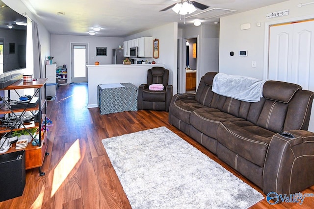 living room with dark wood-type flooring and ceiling fan