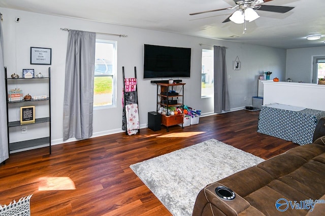 living room featuring dark wood-type flooring and ceiling fan