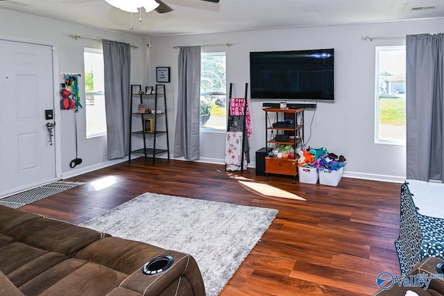 living room with dark wood-type flooring and ceiling fan