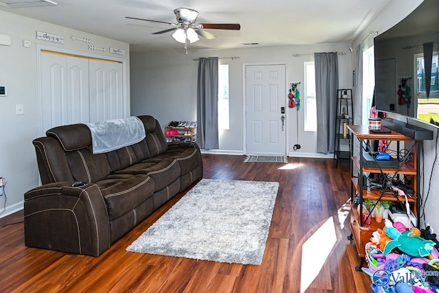 living room featuring ceiling fan and dark hardwood / wood-style flooring