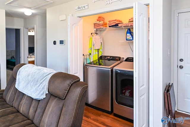 clothes washing area with separate washer and dryer and dark hardwood / wood-style flooring