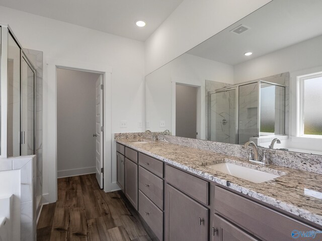 bathroom with vanity, a shower with shower door, and hardwood / wood-style floors