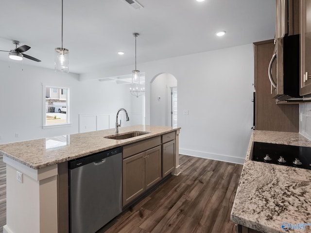 kitchen with sink, stainless steel appliances, pendant lighting, dark wood-type flooring, and a center island with sink