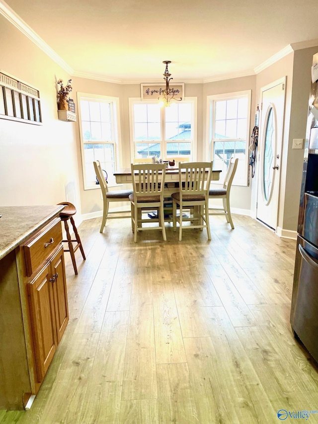 dining room featuring crown molding, light hardwood / wood-style flooring, and a notable chandelier