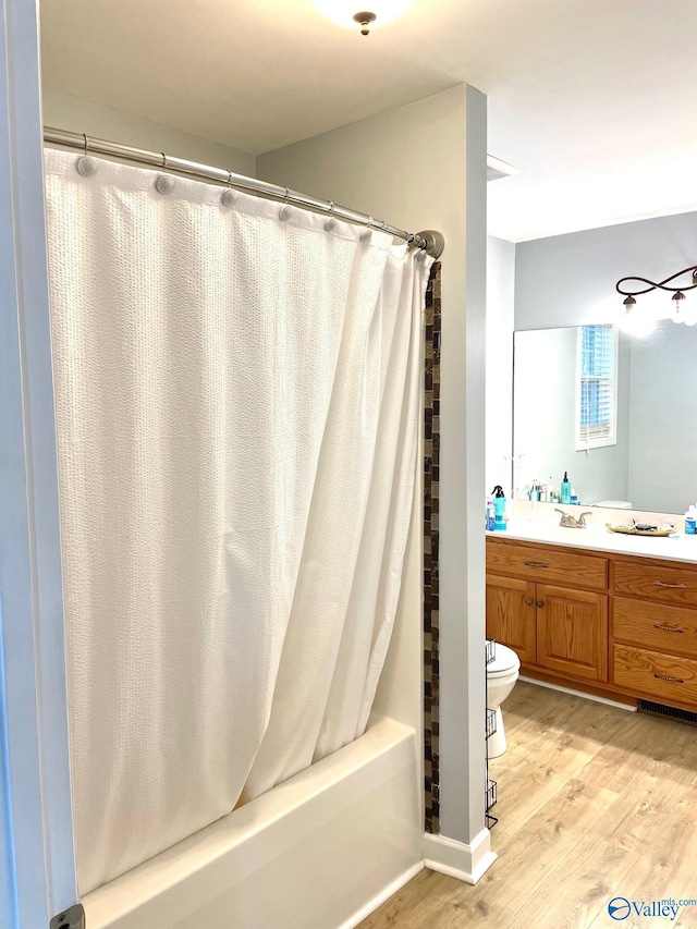 full bathroom with vanity, toilet, shower / bathtub combination with curtain, and wood-type flooring