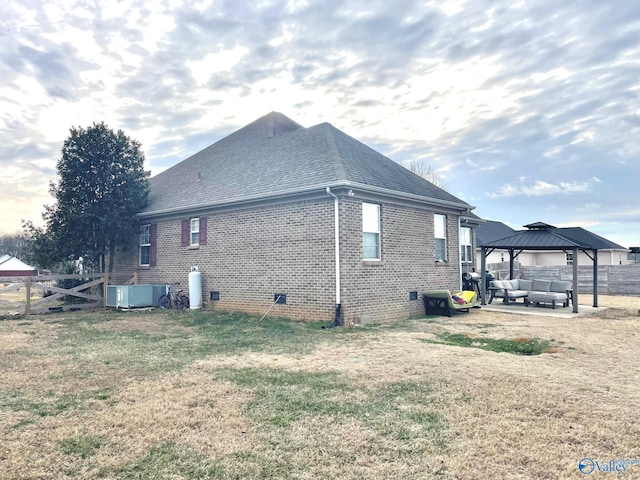 view of side of home featuring a patio area, an outdoor hangout area, central air condition unit, a gazebo, and a yard