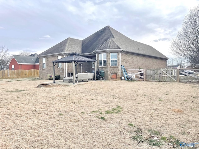 rear view of property with an outdoor living space, a patio area, and a gazebo