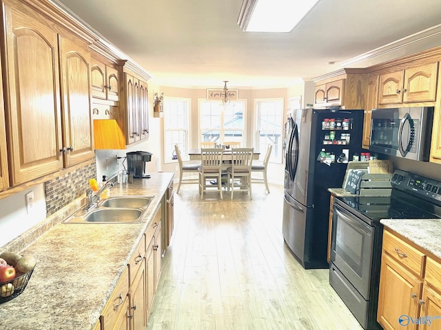 kitchen with light hardwood / wood-style flooring, sink, decorative light fixtures, a chandelier, and stainless steel appliances