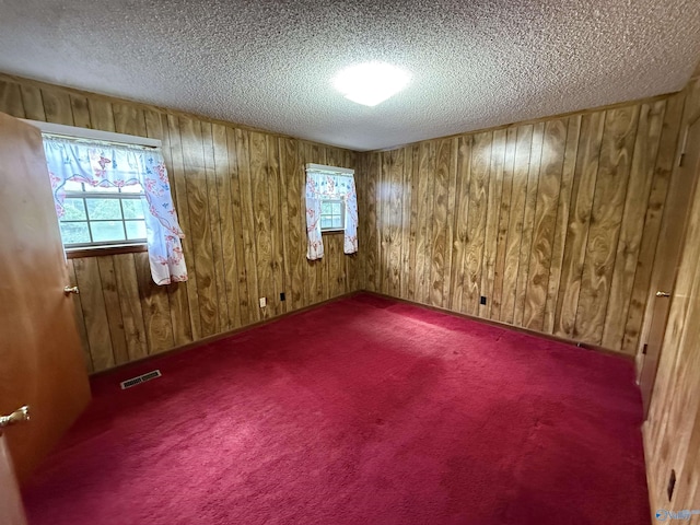 4435 Pilgrims Rest Rd, Southside, AL 35907 - empty room featuring a textured ceiling, wood walls, and carpet