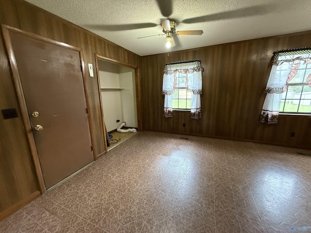 4435 Pilgrims Rest Rd, Southside, AL 35907 - unfurnished bedroom featuring a textured ceiling, wooden walls, and a ceiling fan