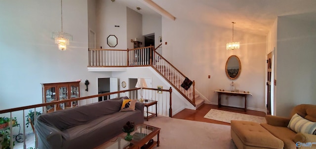 living room with a notable chandelier, hardwood / wood-style floors, and high vaulted ceiling