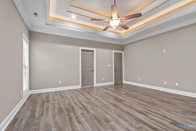 unfurnished bedroom featuring crown molding, hardwood / wood-style floors, ceiling fan, and a tray ceiling